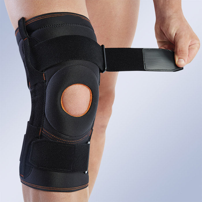 Windowed knee brace with patellar centering and lateral stabilizers
